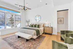 Bedroom with light wood finished floors and suspended lighting