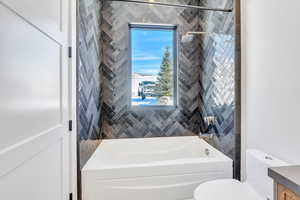 Bathroom featuring vanity and washtub / shower combination