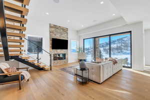 Living area with light wood-type flooring, a fireplace, and recessed lighting