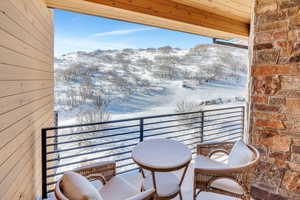 Snow covered back of property with a mountain view