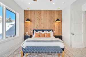 Bedroom featuring wood walls, an accent wall, recessed lighting, and a ceiling fan