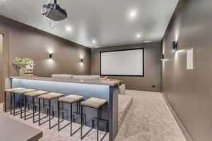 Home theater with recessed lighting and light colored carpet