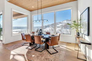 Dining area featuring wood ceiling, a mountain view, and light wood-style floors