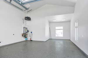 Garage featuring a heating unit and tankless water heater