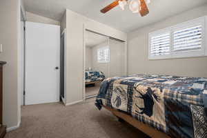 Bedroom featuring light colored carpet, a closet, and ceiling fan