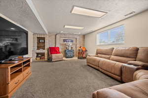 Living room with carpet flooring, brick wall, and a textured ceiling