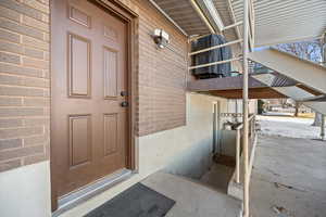 View of exterior entry featuring brick siding