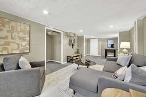 Carpeted living area featuring recessed lighting and a textured ceiling