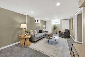 Basement living area with carpet floors and recessed lighting