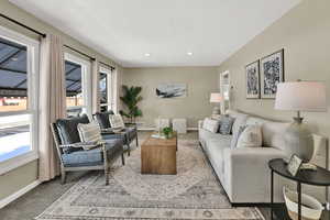 Carpeted living room featuring baseboards and recessed lighting