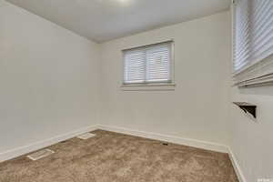 Carpeted empty room featuring baseboards