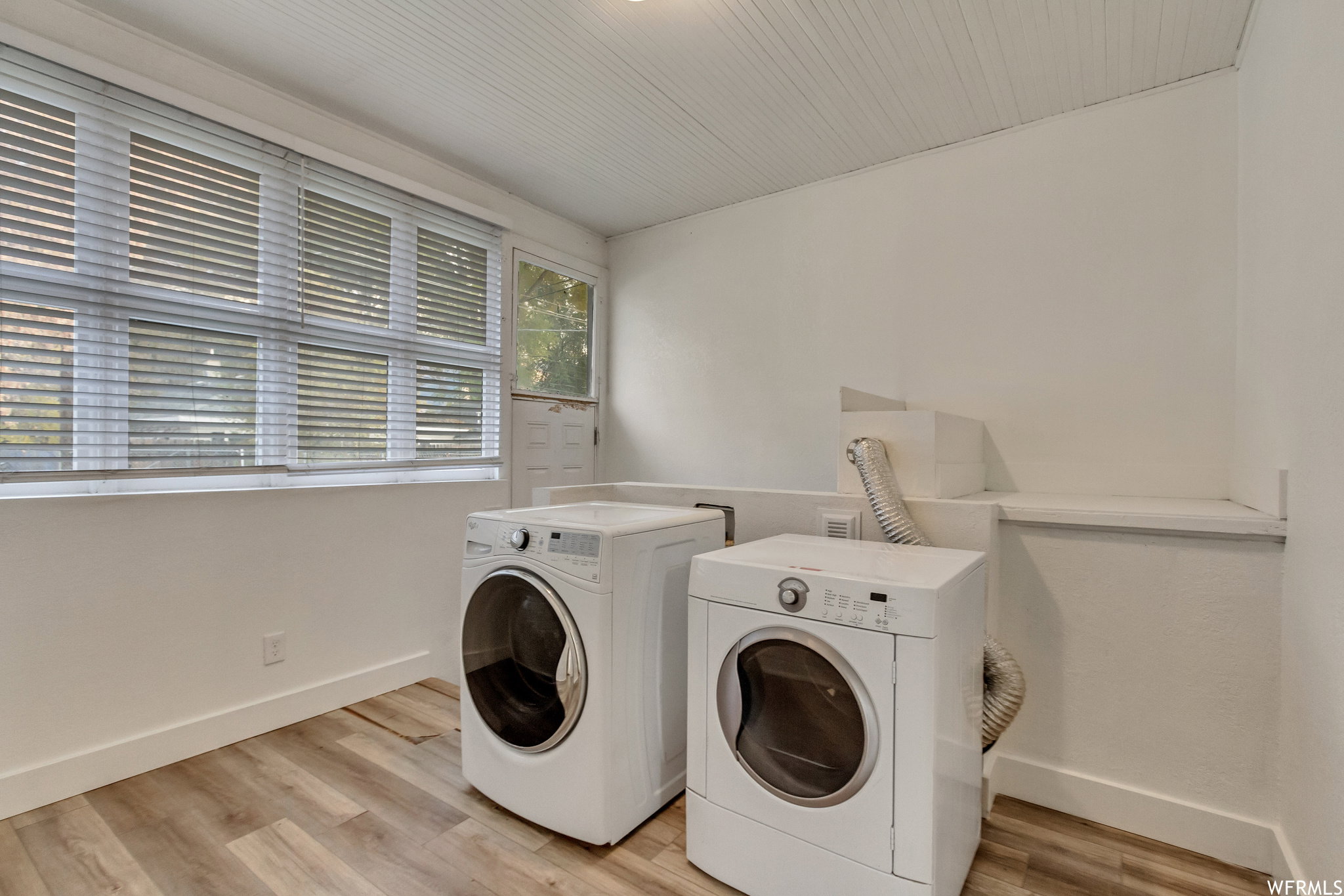 Laundry room with light wood-style flooring and washer and dryer