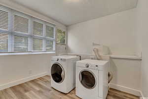 Laundry room with light wood-style flooring and washer and dryer