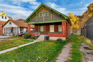 Bungalow-style house with a porch, brick siding, and a gate