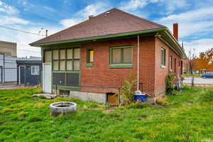 Rear view of property featuring a chimney and brick siding