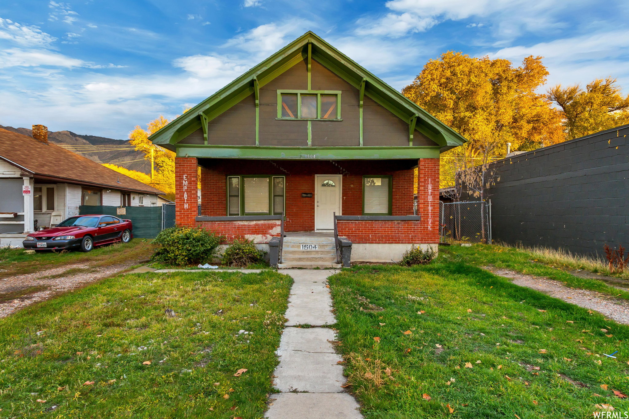 Bungalow-style house featuring covered porch and brick siding