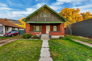 Bungalow-style house featuring covered porch and brick siding
