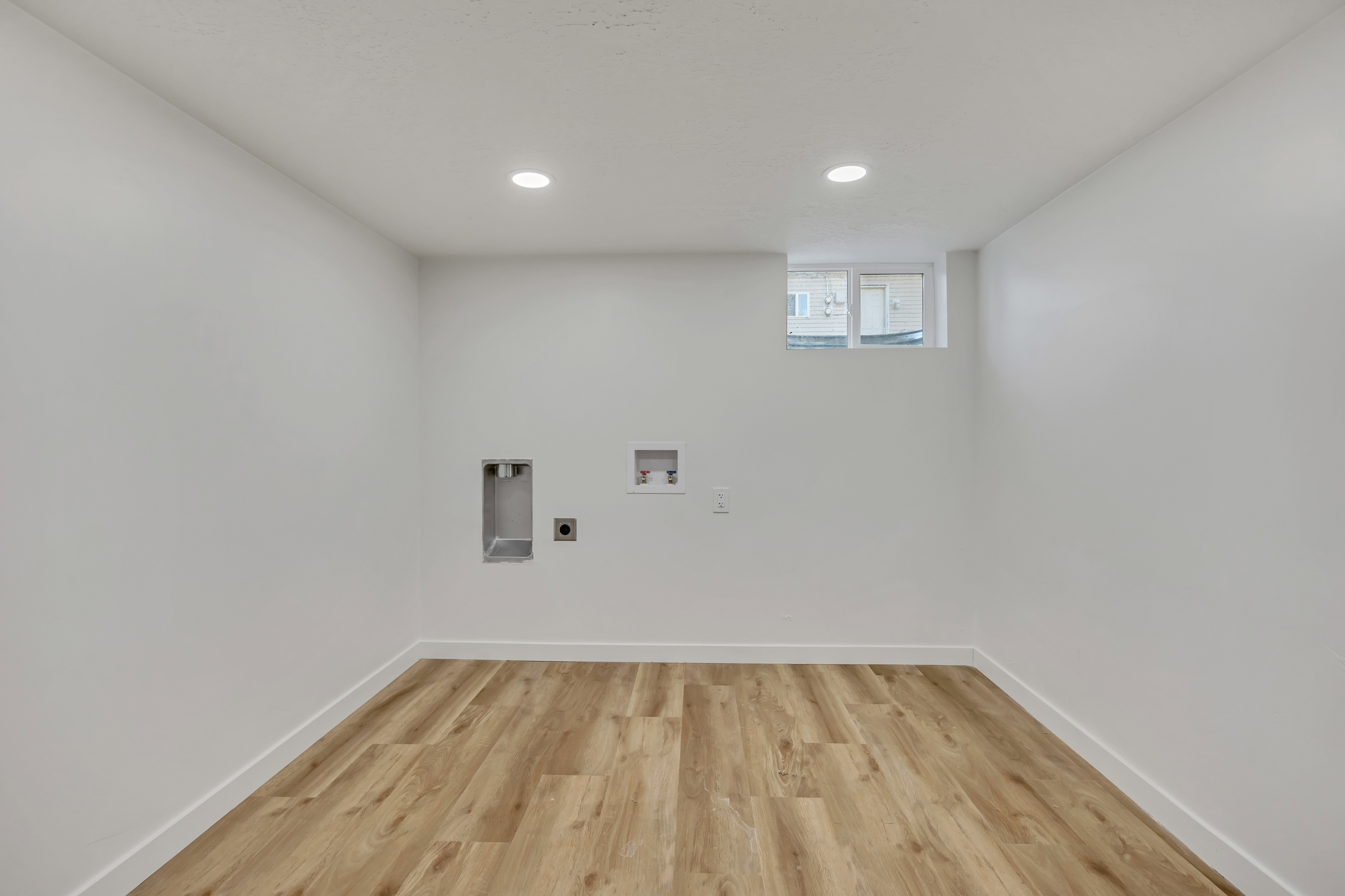 Laundry area featuring light wood-type flooring, recessed lighting, and washer hookup