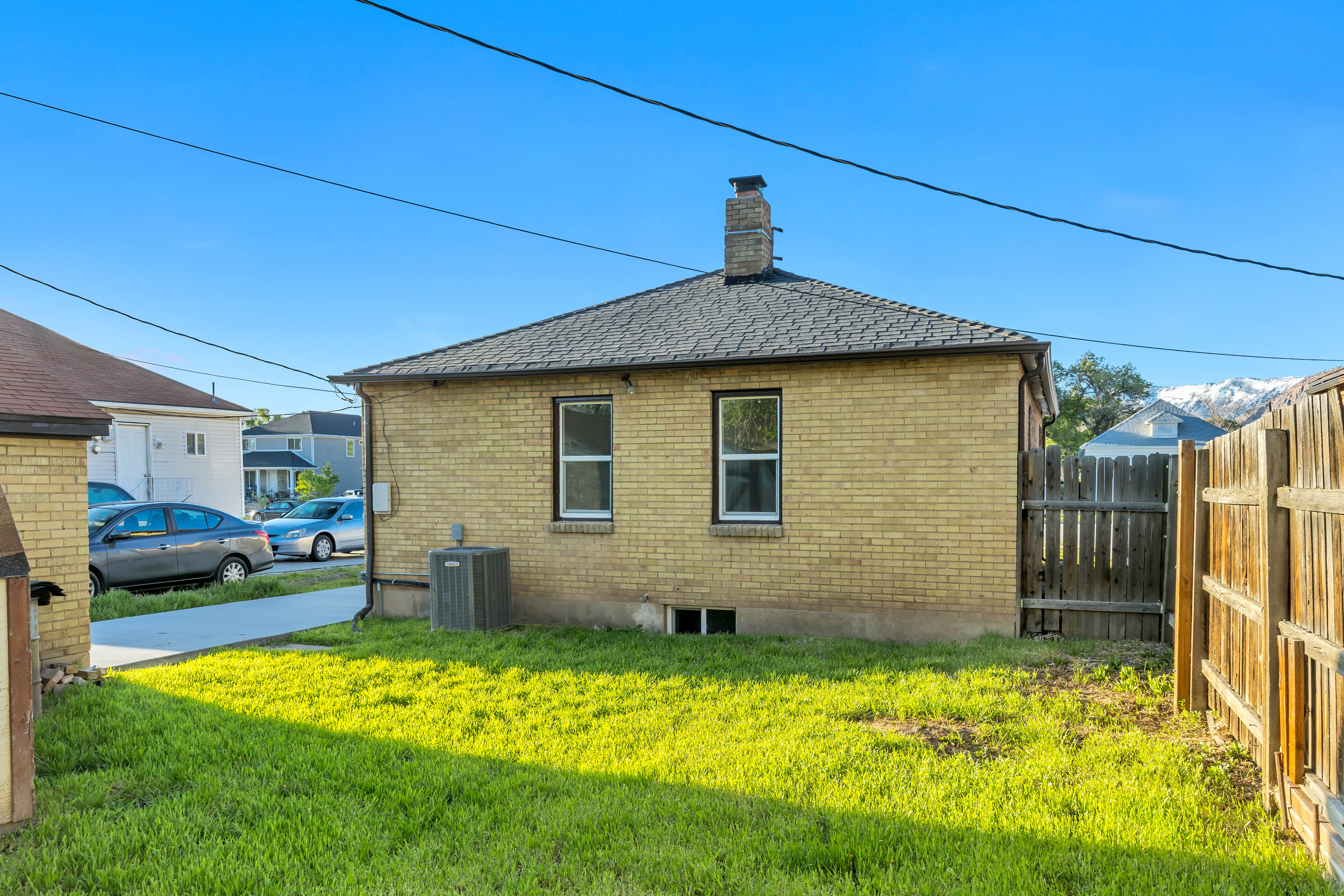 View of home's exterior featuring brick siding, a chimney, and roof with shingles