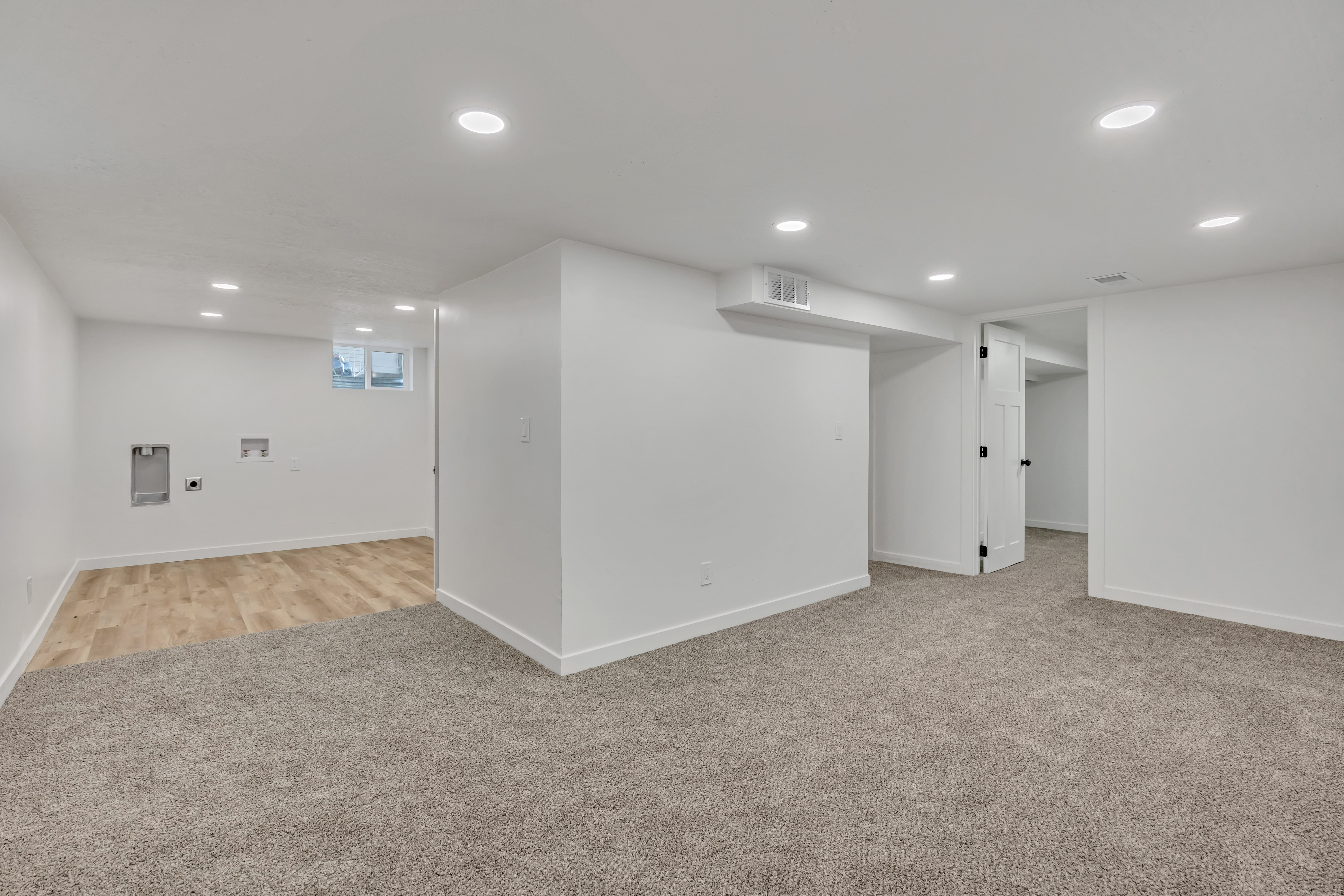 Below grade area with light colored carpet and recessed lighting