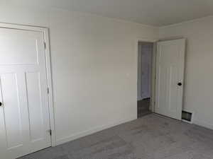 Unfurnished bedroom featuring ornamental molding and carpet floors