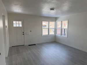 Foyer with light wood-style floors and a textured ceiling