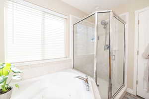 Bathroom with a shower stall and a tub with jets