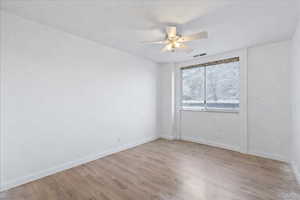 Empty room featuring light wood-type flooring and ceiling fan