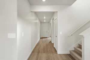 Corridor featuring light wood-style flooring and recessed lighting