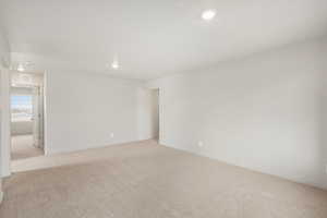 Empty room featuring light carpet and recessed lighting