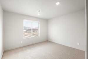 Spare room featuring light colored carpet and recessed lighting