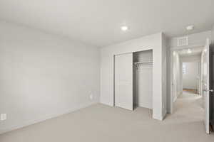 **DISCLAIMER** Interior package & colors may vary. Unfurnished bedroom featuring light carpet and a closet