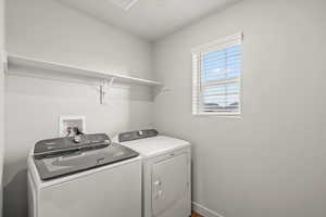 Laundry room with washing machine and dryer and baseboards