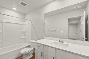 **DISLCAIMER** Interior package & colors may vary. Bathroom with vanity, shower / bathtub combination, a textured ceiling, dark wood-style flooring, and recessed lighting