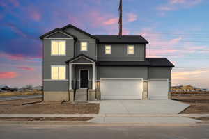 View of front of home with driveway and a garage