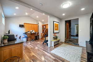 Office area featuring lofted ceiling, light wood finished floors, and recessed lighting