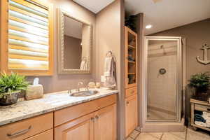 Bathroom with a stall shower, vanity, and light tile patterned floors