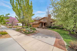 View of front of home with concrete driveway, a mountain view, stucco siding, a front lawn, and a garage