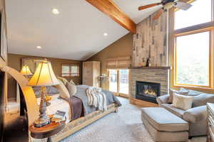 Carpeted bedroom with access to exterior, vaulted ceiling, a large fireplace, and recessed lighting