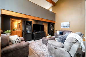 Living area with carpet flooring and vaulted ceiling