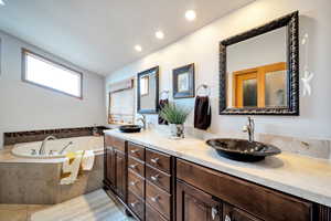 Bathroom with double vanity, a garden tub, recessed lighting, and light tile patterned floors