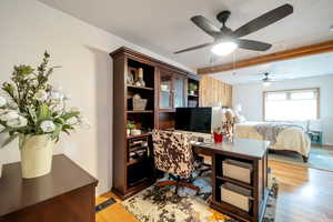 Bedroom with an office area, ceiling fan, and light wood finished floors