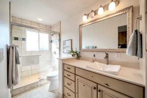 Full bath with vanity, a shower stall, and light tile patterned flooring