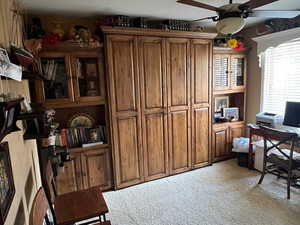 Home office featuring light carpet and ceiling fan