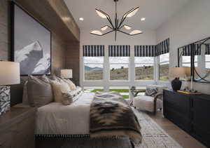 Bedroom featuring suspended lighting, wood finished floors, and wooden walls