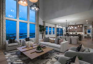 Living room featuring wood finished floors, recessed lighting, and a high ceiling