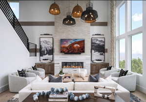 Living room featuring wood finished floors, a high ceiling, and a tiled fireplace