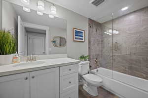 Full hall bathroom with tiled tub surround, tub and shower.   Full glass door.