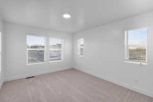 Spare room featuring light colored carpet and baseboards