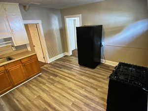 3 bedroomsKitchen featuring black appliances, dark wood-style floors, and light countertops